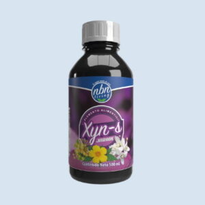 Un frasco de jarabe "xyn-s", etiquetado como complemento alimenticio, que contiene 500 ml de líquido. la etiqueta presenta gráficos florales y se presenta sobre un fondo azul claro.